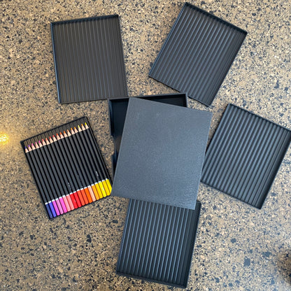 A black colored pencil caddy with multiple colored pencils visible, placed next to a gray lid or cover2