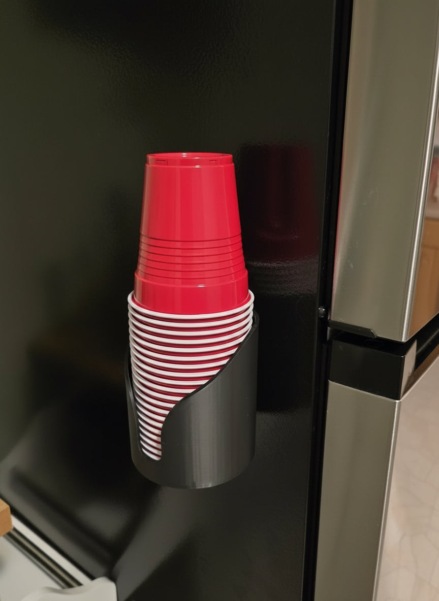 Stack of red plastic cups in a holder on a black refrigerator.