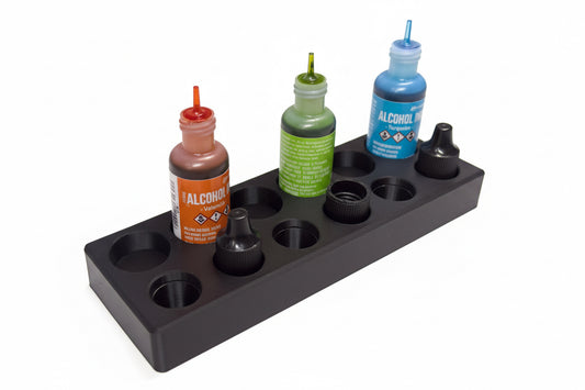 Black ink holder with four bottles of different colored inks on a white background